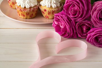 Sweet romantic cupcakes for Valentine's Day on a white wooden background. Selective focus