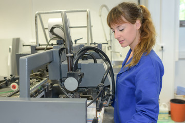 Female worker stood by factory machinery