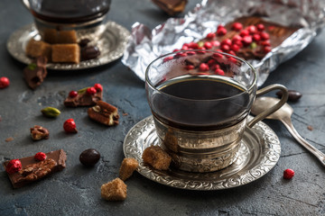 Vintage coffee cup, chocolate and cherries on the dark background