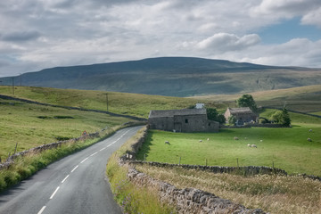 Fototapeta na wymiar English countryside with road and green hills