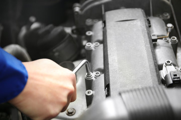 Mechanic repairing car with open hood
