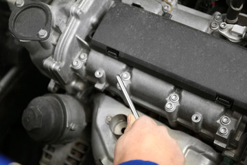 Mechanic repairing car with open hood