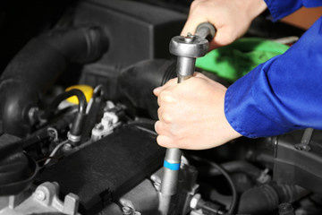 Mechanic repairing car with open hood