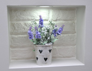 the niche in the brick wall illuminated vase with flowers