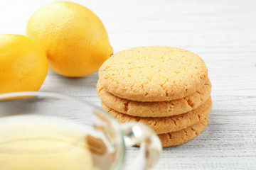 Fototapeta na wymiar Delicious cookies with tea and lemons on white wooden background