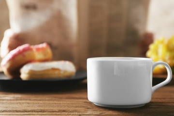 Cup of fresh hot coffee and breakfast on table, closeup