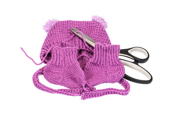 Knitted hats and socks, and a pair of scissors on a white background.