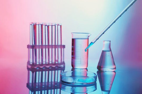 Chemical test-tubes with medicine dropper on color background