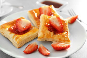 Sweet tasty pastries on plate on table