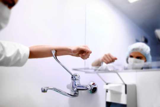 Surgeon washing hands at sink