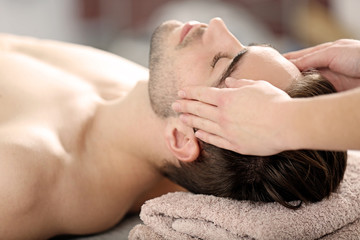 Obraz na płótnie Canvas Man having face massage in spa salon