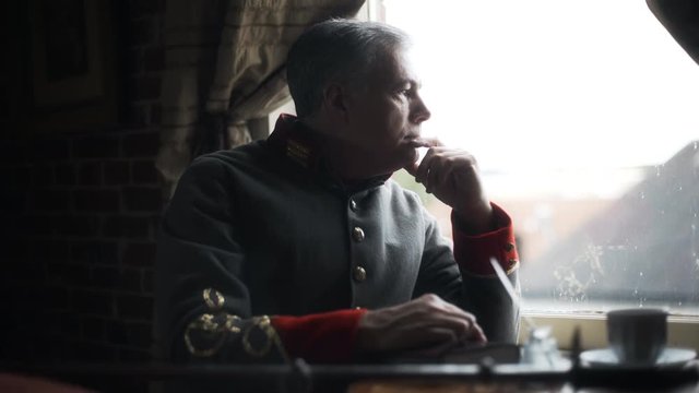 confederate captain sitting at a window thinking and pondering 4k