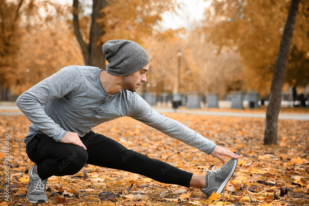 Sticker handsome young man stretching in autumn park