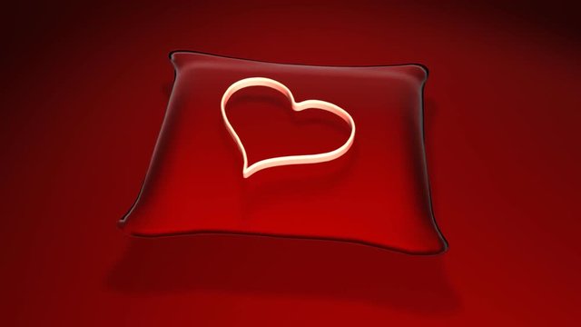 3D rotating heart over a red pillow
