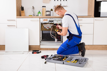Technician Checking Dishwasher With Digital Multimeter