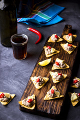 Chips with a forcemeat stuffing, a lime and hot pepper  on a chopping board.