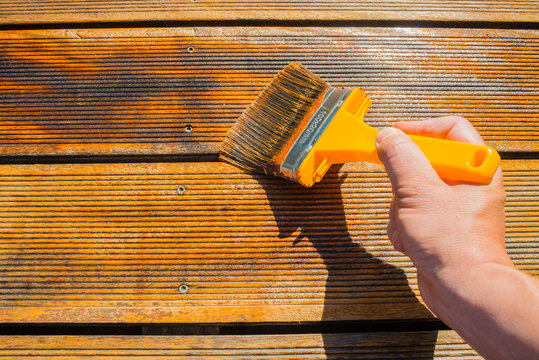 Oiling Terrace with Wide Brush - painting wooden patio deck with protective oil
