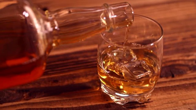 Pouring whiskey into glass in detail
