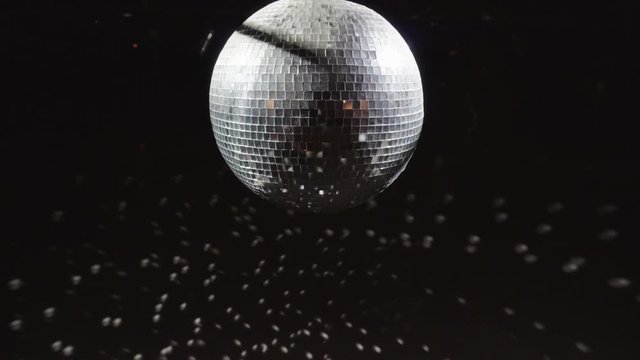 Disco mirrorball discoball spinning and reflecting light into a club venue