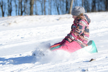 Enfant joue en plein air dans la neige. fille et sa luge.