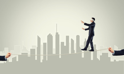 Business concept of risk support and assistance with man balancing on rope