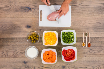 Person Cutting Meat On Chopping Board