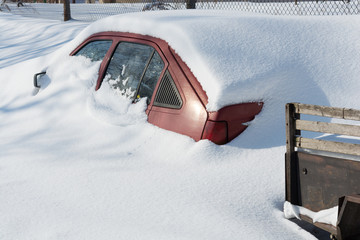 Car buried under deep snow after a snow storm. Snowdrift