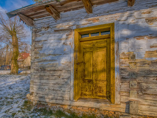 White wooden log house with yellow door