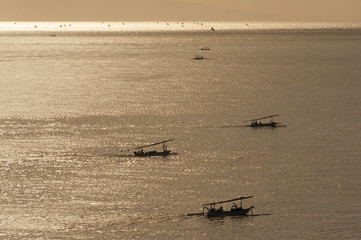 Bali Fishing Boats at Dawn. Balinese outrigger fishing boats, called jukung, fish at night and return to shore early in the morning to unload and sell their catch, usually makerel or barracuda.