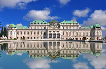 View of famous Belvedere palace with a reflection in pool and blue sky, in Vienna, Austria - obrazy, fototapety, plakaty