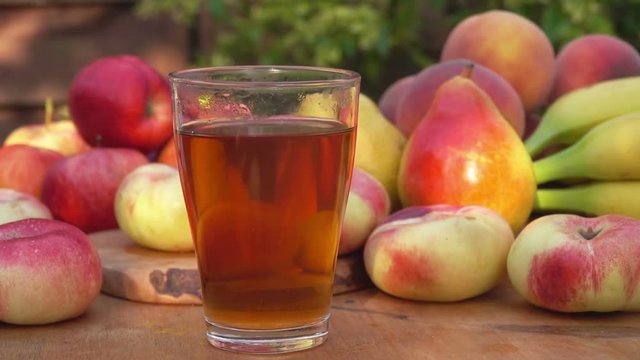 Peach juice in a glass on a background of fruit