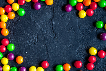 sweets and sugar candies on dark background top view