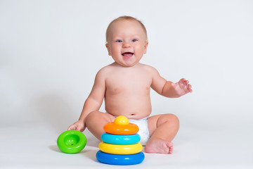 Fototapeta na wymiar smiling child baby playing with color pyramid toy isolated.