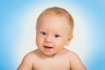 Little boy laughing. Close-up Portrait against blue background.
