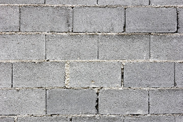 Gray concrete bricks laid in layers on top of each other - masonry