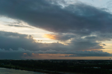 Cumulus sunset clouds with sun setting down