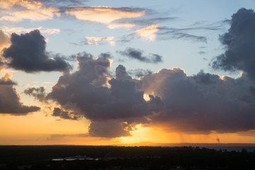 Cumulus sunset clouds with sun setting down