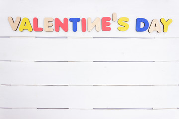 Valentine's Day inscription of colored wooden letters on white background, hearts