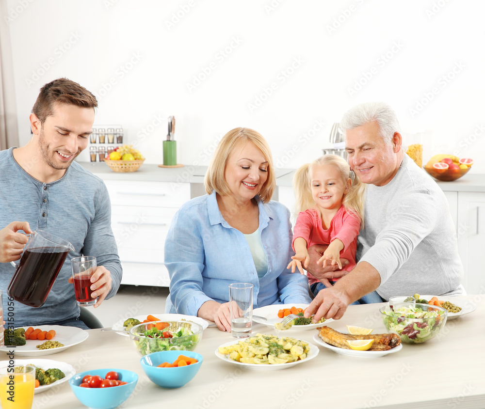 Poster Happy family having lunch in kitchen