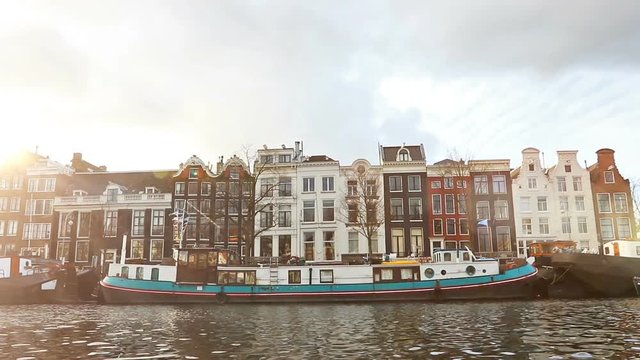 Amsterdam, Netherlands - January 3: Slow motion video of view from the canal to the streets, canals with old flamish houses and bridges in Amsterdam, Netherlands.