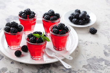 Jelly dessert with fresh blackberries served in glass, selective focus