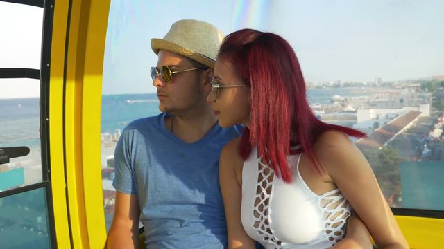 Young couple on the ropeway at the seaside watching the landscape