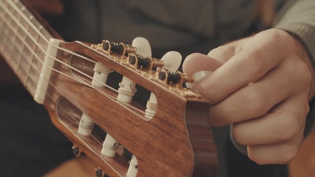 Guitarist's hands tuning guitar