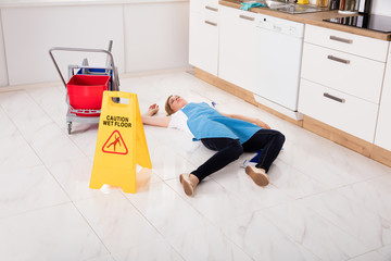 Fainted Housemaid Lying On Floor In Kitchen
