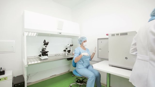 Two woman scientists working in microbiological laboratory, ivf lab - embryologists working with samples.