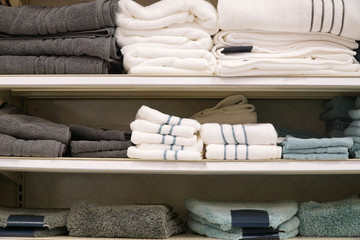 stacking bath towels arranged on the shelf in store