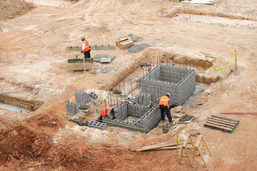 worker working on basement of building at construction site