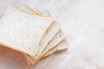 Sliced whole wheat bread on wooden background.