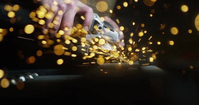 locksmith with a laser cuts in half a sheet of steel causing sparks.The laser heat Nicks iron up to get clean cuts and perfect for buildings with wrought iron.Concept: industry,technology,engineering.