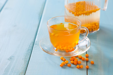 Vitaminic healthy sea buckthorn tea  with fresh raw sea buckthorn berries, selective focus, copy space